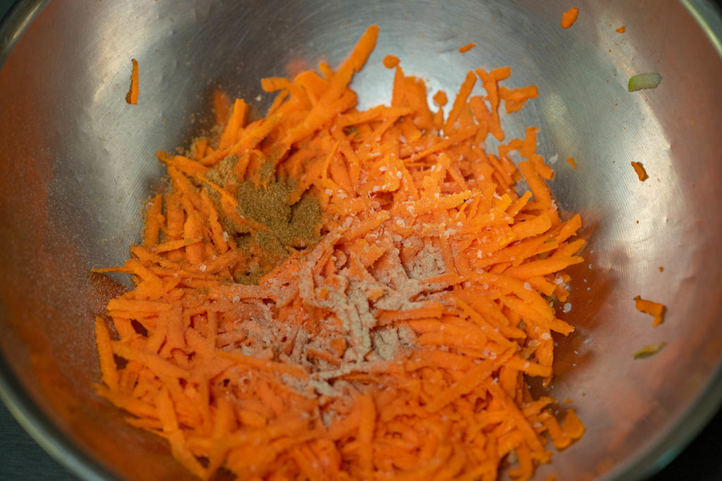 Add seasonings to the shredded carrots