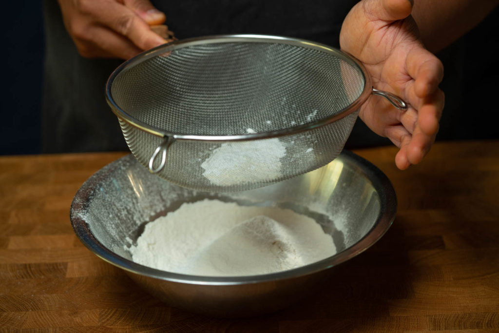 In a separate bowl, sift flour and baking powder