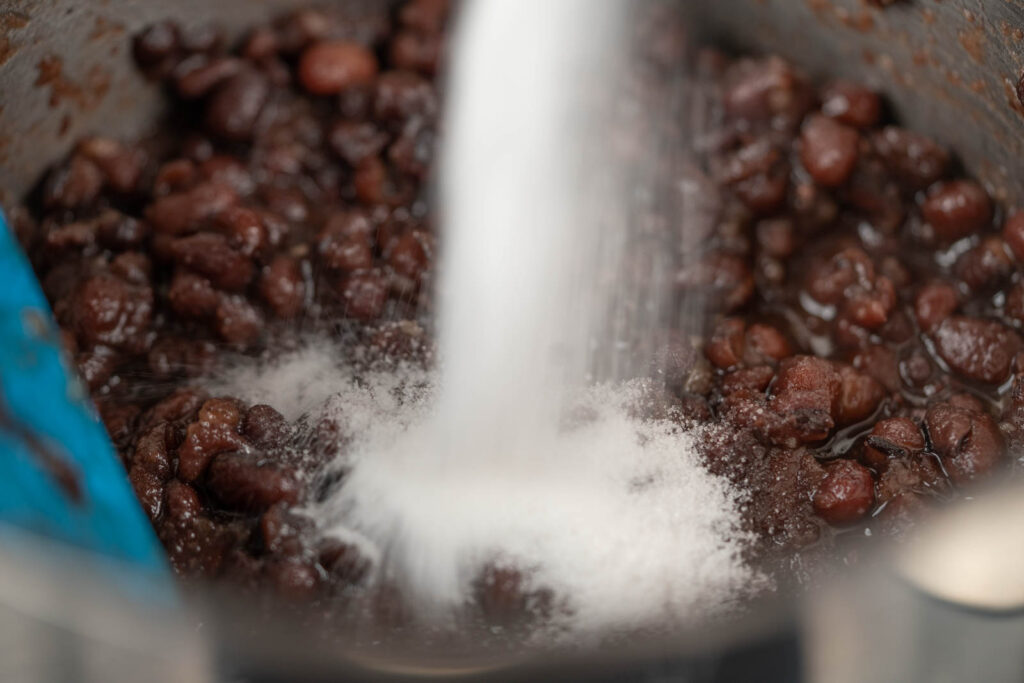 Sugar poured into cooked red beans