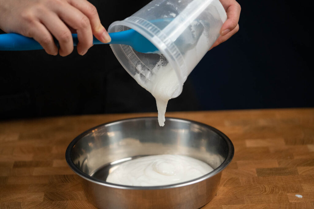 Pouring mochi dough into steaming bowl